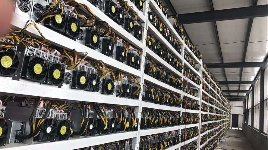 A close-up view of a miner inspecting a mining rig, highlighting the intricate components and maintenance involved.